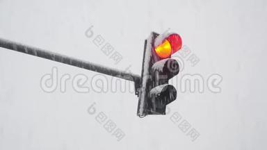 冬季白天雪中的交通灯从红色，琥珀到绿色.. 冬季大雪期间，交通灯管制交通